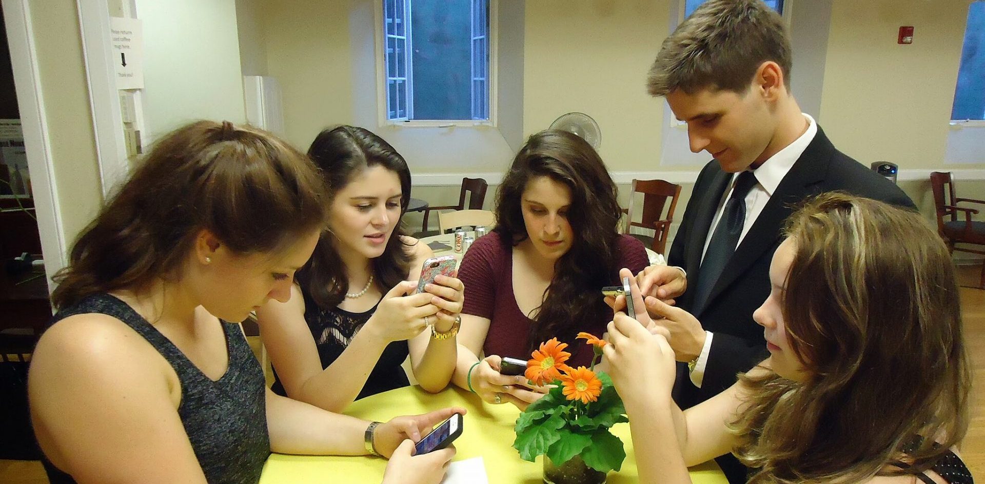 Young people at a party using their smartphones. Publishers are increasingly looking to young, mobile audiences for subscription growth. Image by Tomwsulcer, CC0, via Wikimedia Commons