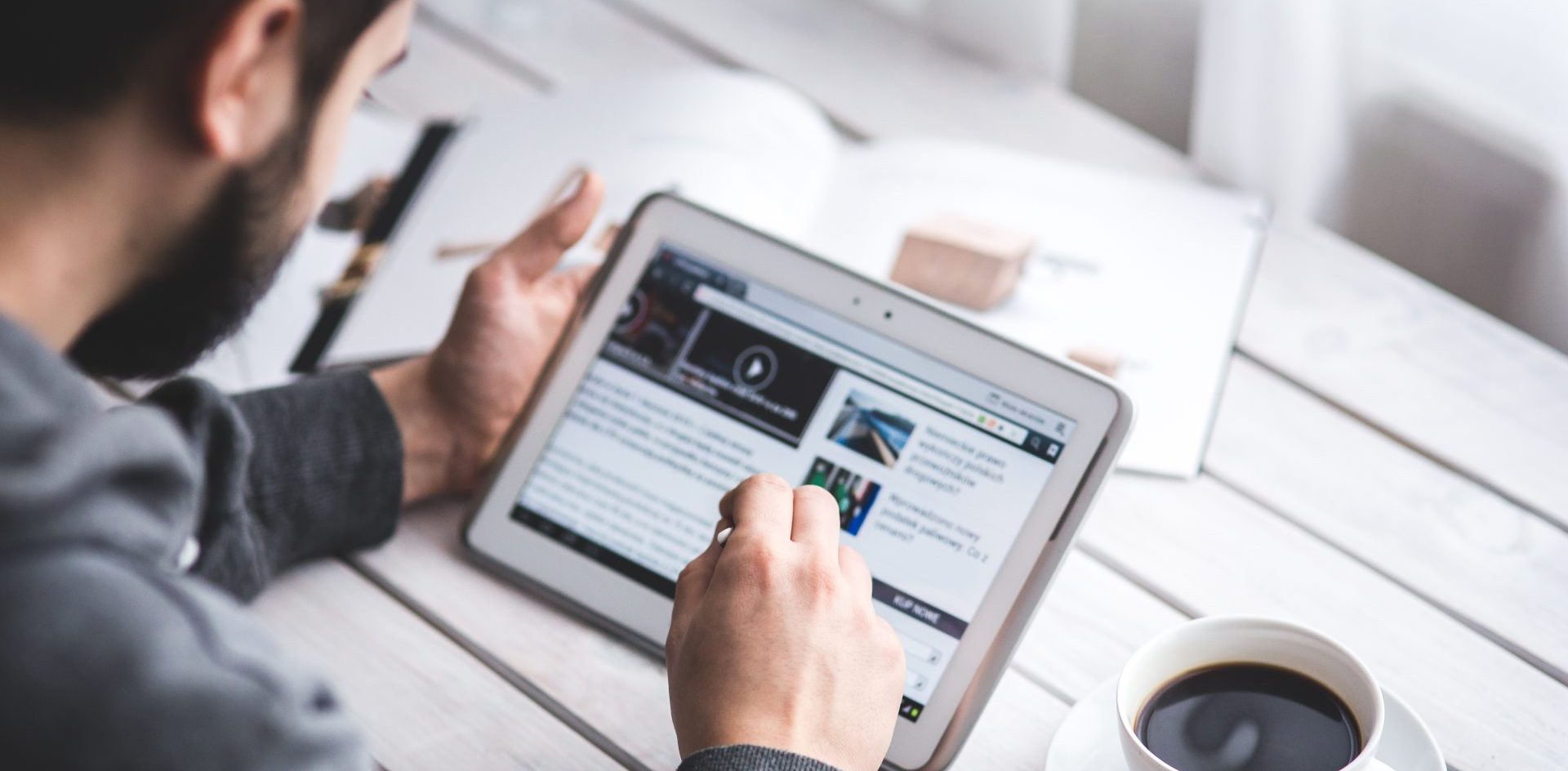 A man uses a news app on a tablet. Apps offer an expanding number of options to grow revenue for news publishers. Photo Public Domain