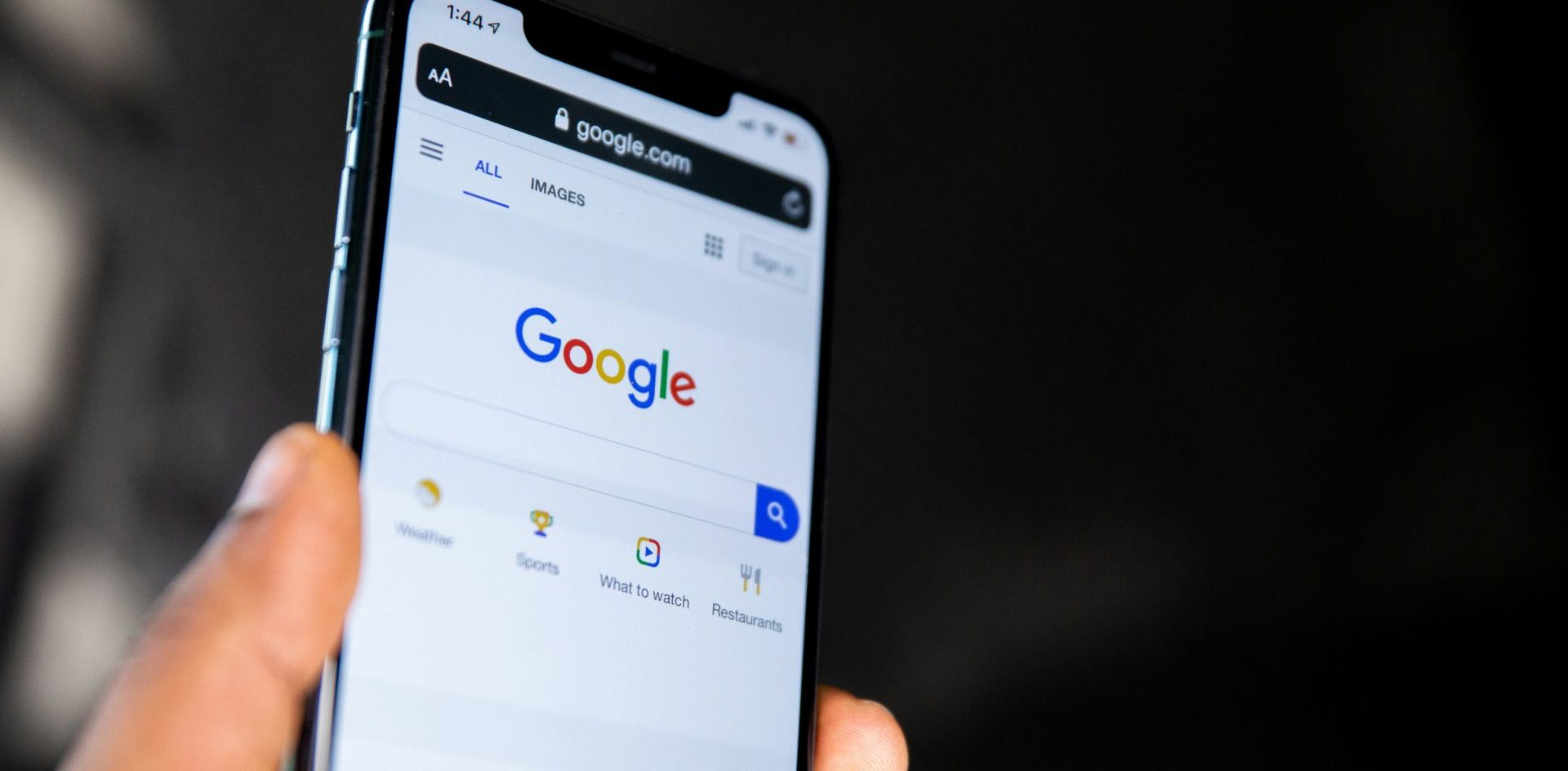 A person holds a smartphone with Google search on the screen. Photo by Solen Feyissa on Unsplash