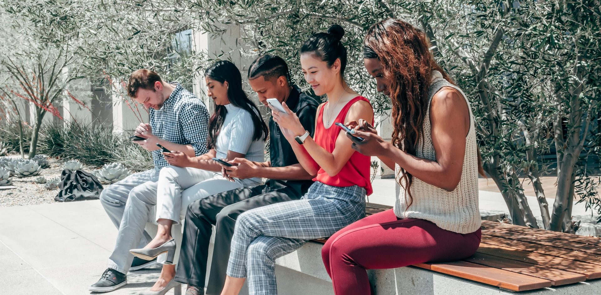 People Using Their Smartphones while Sitting on a Bench. Young audiences use mobile, but they also want content they can relate to. Photo by KindelMedia